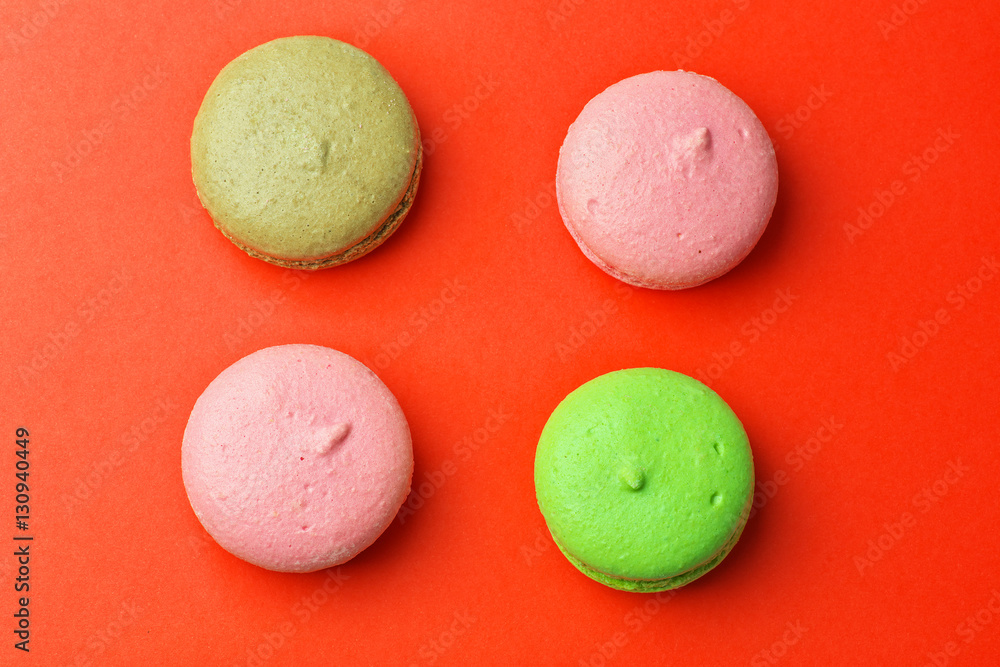 Tasty different colored macaroons on red background Tasty different colored macaroons on red background