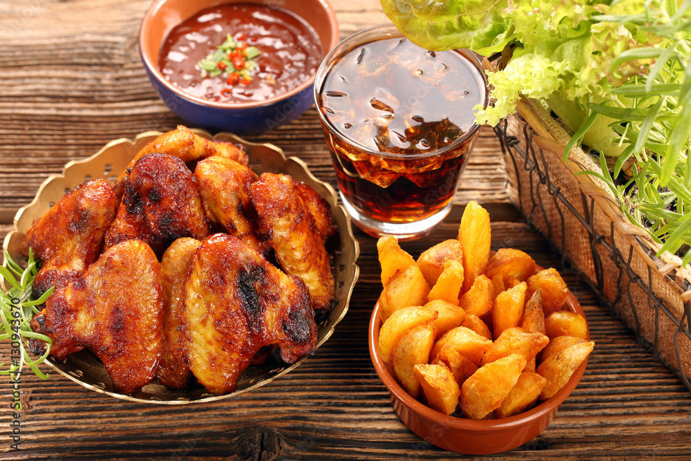Chicken hot wings with baked potatoes and barbecue sauce Chicken hot wings with baked potatoes and barbecue sauce