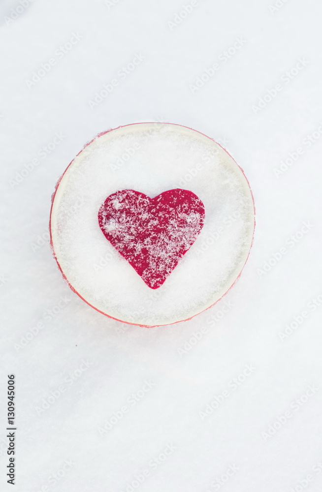 Red felt heart in a bowl on snow, Valentine's Day. Copy space for text. Snowflakes on heart. Valentines day, love concept. White background
