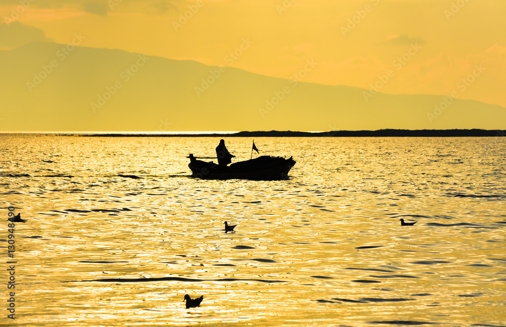 Fishing boat on the sea at sunset.