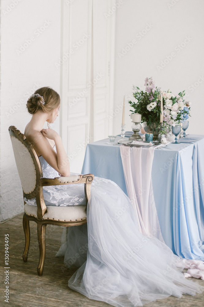 Portrait of young beautiful modern sitting in a armchair bride in a grey lace dress. Portrait of young beautiful modern sitting in a armchair bride in a grey lace dress.