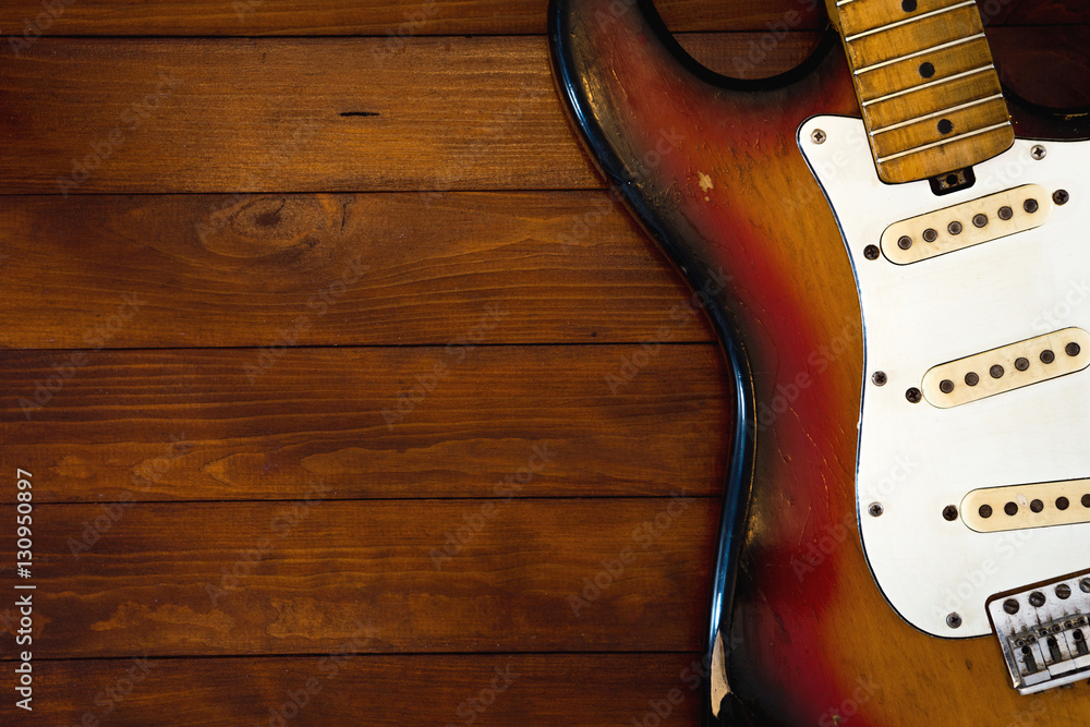 Obraz premium Vintage guitar without strings on background with dark wooden desk