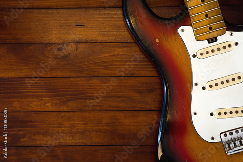 Vintage guitar without strings on background with dark wooden desk
