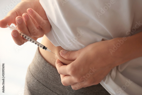 Woman injecting stomach at home © Africa Studio