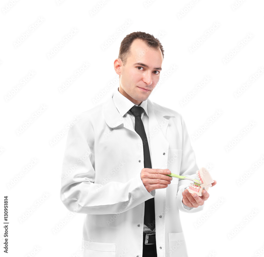 Dentist holding denture and toothbrush isolated on white Dentist holding denture and toothbrush isolated on white