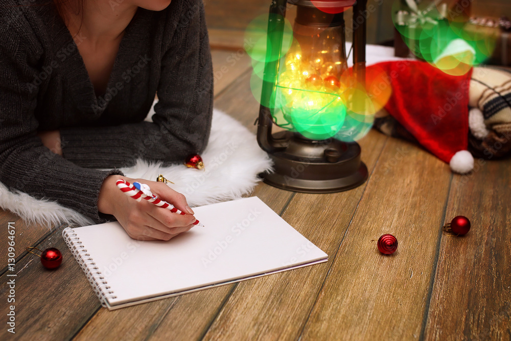Obraz premium girl writes pen on a piece of paper Christmas wishes