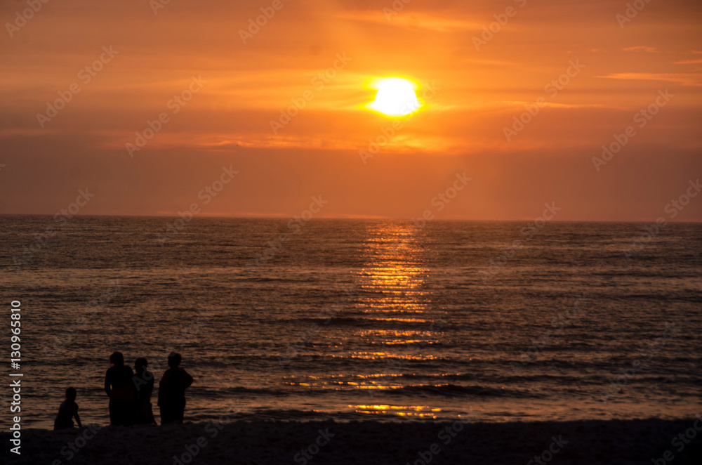 People standing at the beach enjoying the sunset at the North Sea