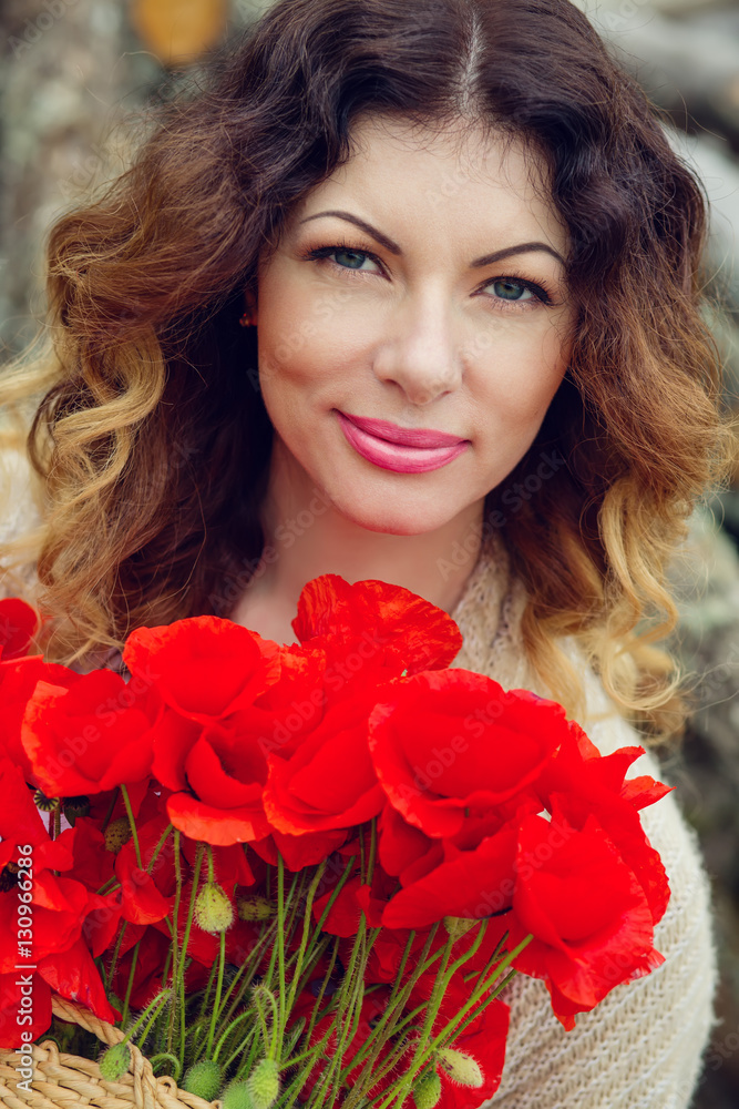 Naklejka premium beautiful young woman with a bouquet of poppies