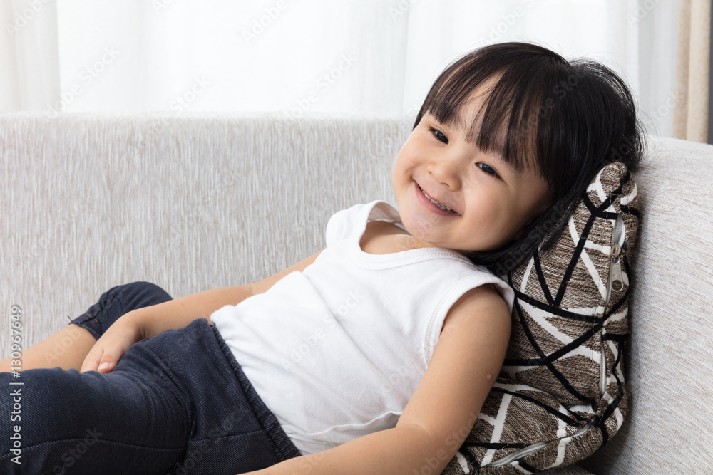 Happy Asian Chinese little girl lying down on the sofa Happy Asian Chinese little girl lying down on the sofa