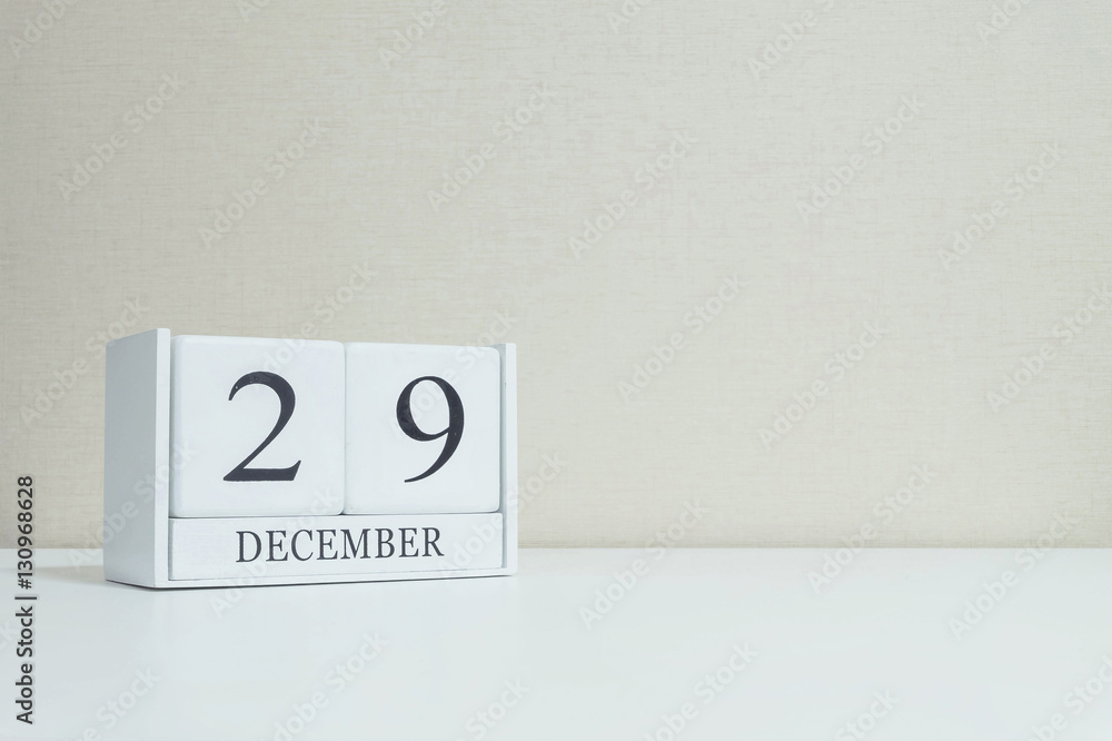 Closeup white wooden calendar with black 29 december word on blurred white wood desk and cream color wallpaper in room textured background with copy space , selective focus at the calendar Closeup white wooden calendar with black 29 december word on blurred white wood desk and cream color wallpaper in room textured background with copy space , selective focus at the calendar