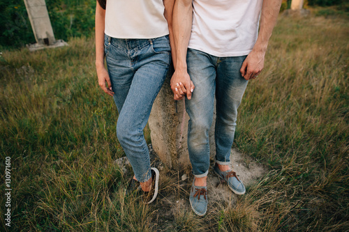 Couple in denim clothes. Couple in love in denim shoes and jeans, holding hands at outdoors.