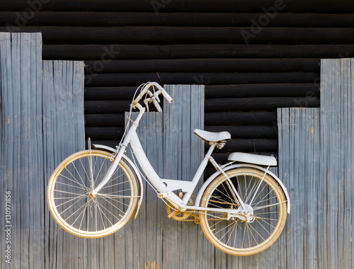 White bicycle on wood wall