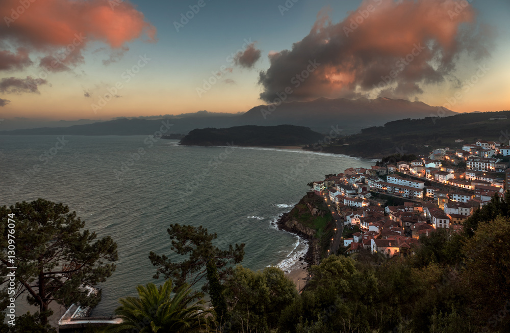 Beautiful view of coastal Asturias sea village Lastres in Spain, Europe during sunset or dusk. Gorgeous panorama of nature traditional famous touristic summer beach destination at dawn.