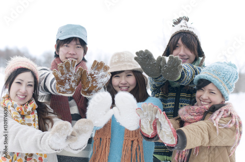 雪のついた手袋を見せる若者たち