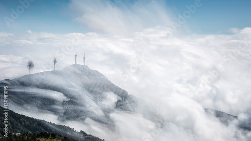 mountain top of wind farms with clouds