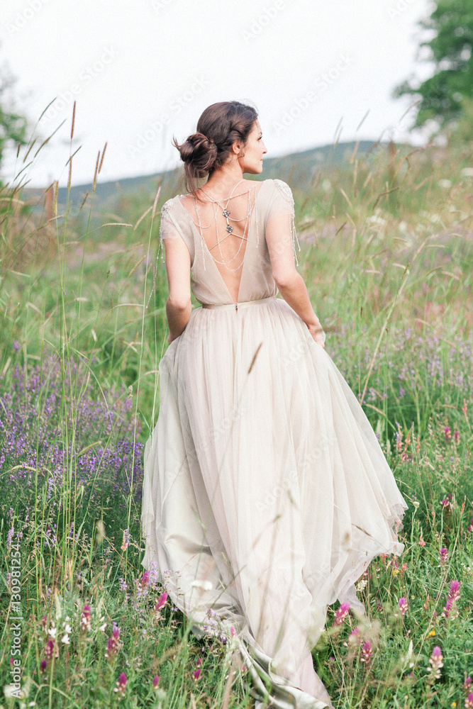 Bride in a beautiful dress with a bouquet of flowers and greener