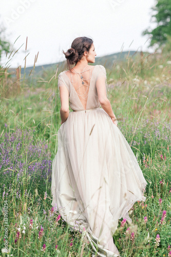 Obraz na płótnie Bride in a beautiful dress with a bouquet of flowers and greener w salonie