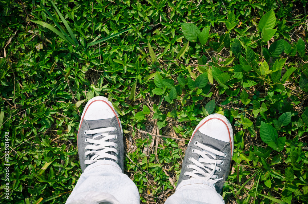 Top view of shoes and blue jean on nature green ground grass, selfie. Top view of shoes and blue jean on nature green ground grass, selfie.