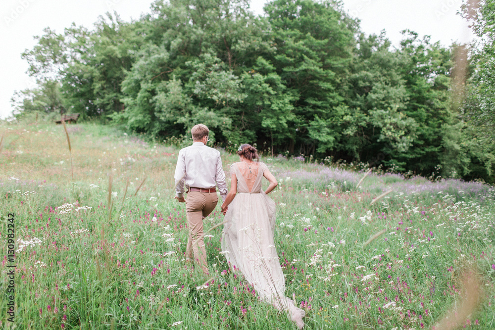 Couple in wedding attire with a bouquet of flowers and greenery