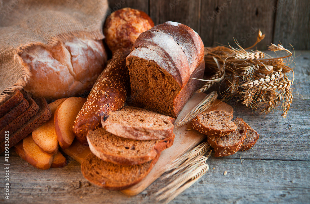 Assortment of fresh baked bread on wooden table background Assortment of fresh baked bread on wooden table background