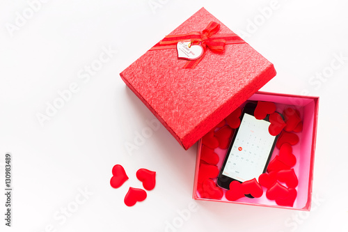 Smartphone with calendar at Valentine's day date in gift box