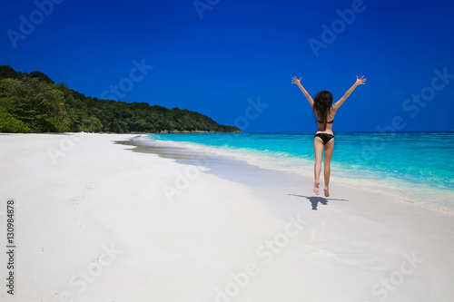 Summer vacation. Beautiful free woman jumping on the exotic sea