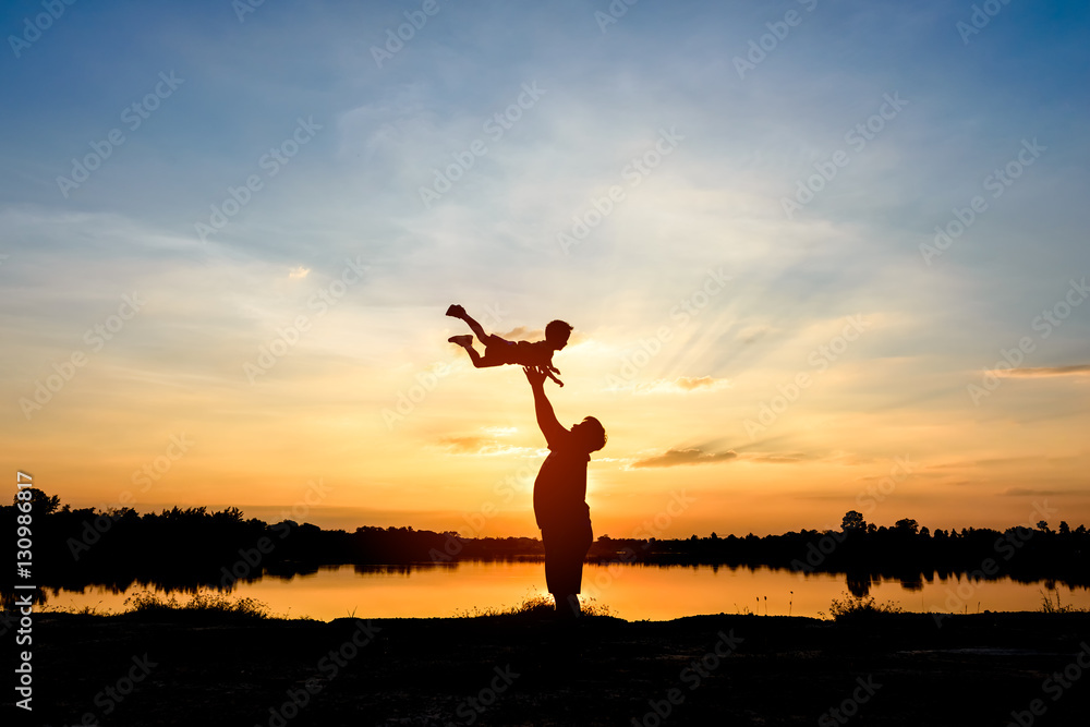 silhouette of father and son at sunset