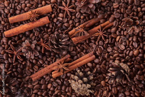 seasoning cinnamon (Cinnamomum) and anise (Anisium vulgare Gaerto) lies on the coffee beans among Christmas pine cones, background, close-up