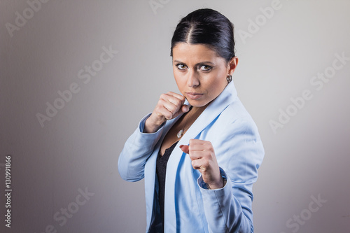 Foto Young businesswoman making a defensive fight pose, crunching her fists