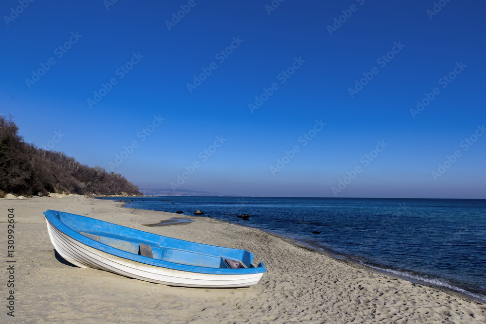 Day landscape of lonely boat on the beach