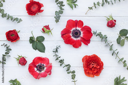 Floral pattern with red flowers on white wooden background photo