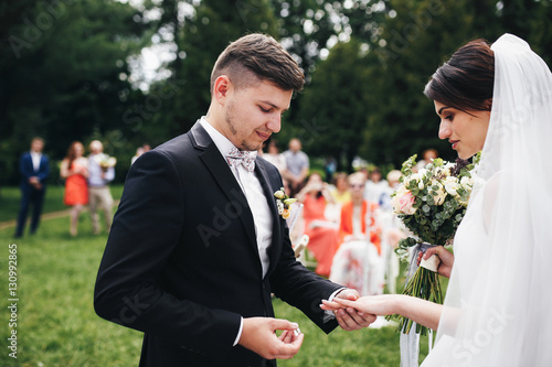 The groom wear a wedding ring for bride