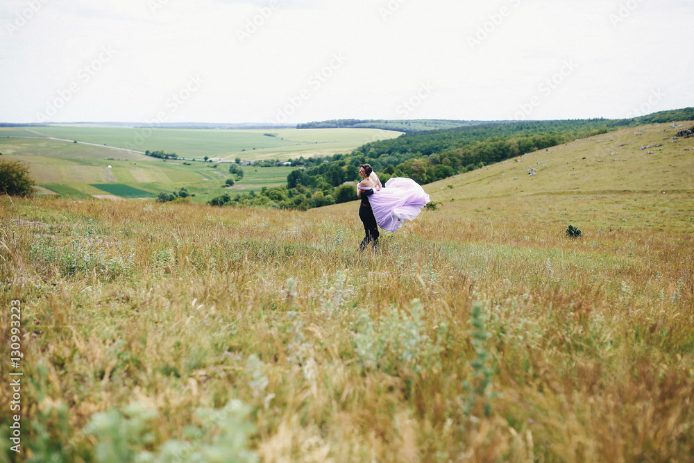 The bridesmaid and groomsman running along field The bridesmaid and groomsman running along field