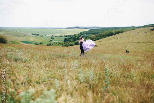The bridesmaid and groomsman running along field © jujik