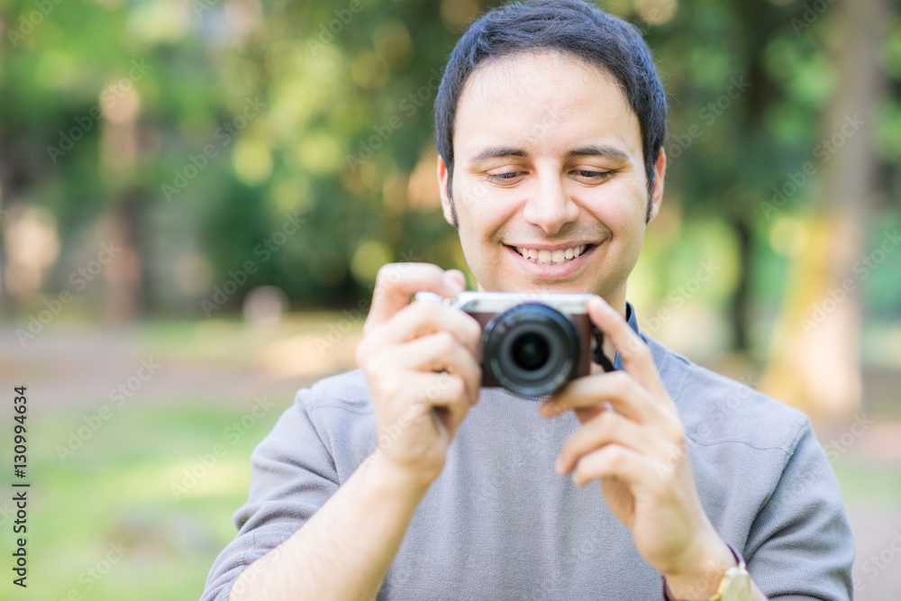 Smiling man using a mirrorless camera