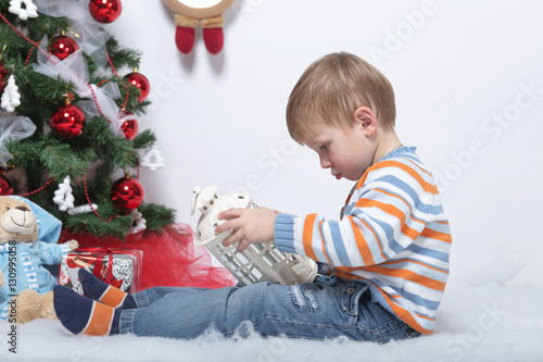 child playing near the Christmas tree on a white background