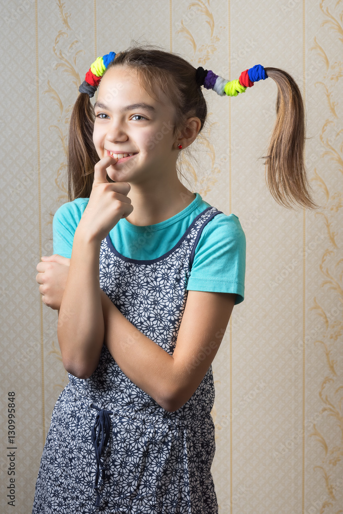 Mischievous 11-year-old girl is thinking about what to do, leaning his finger to her mouth. Mischievous 11-year-old girl is thinking about what to do, leaning his finger to her mouth.