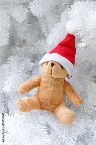Teddy bear wearing a santa hat isolated on white Christmas tree