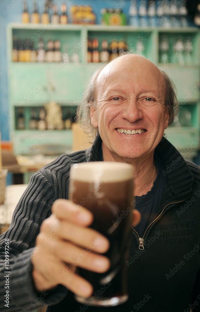 Uomo tiene pinta di birra in un pub Uomo tiene pinta di birra in un pub