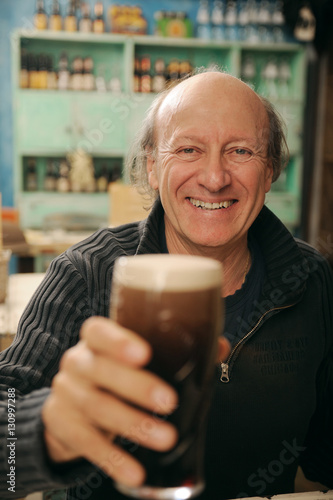 Adulto sorridente  al pub con una birra