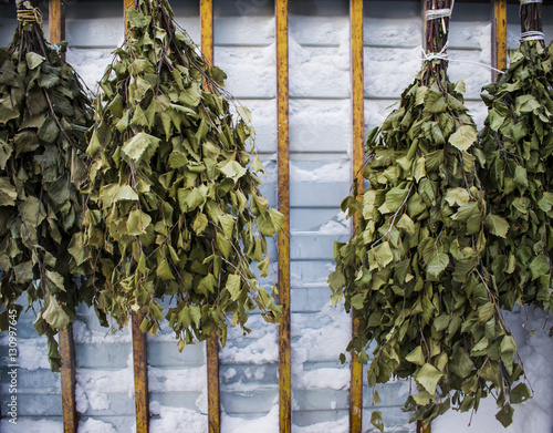 Dry birch brooms for a bath hanging on the wall