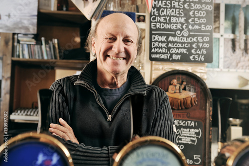 Uomo proprietario di un pub con le braccia incrociate
