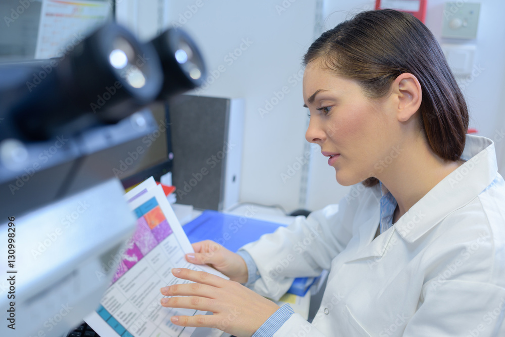 Laboratory technician reading chart Laboratory technician reading chart
