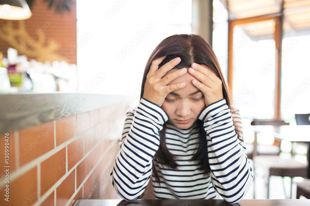 Woman has headache in the cafe Woman has headache in the cafe