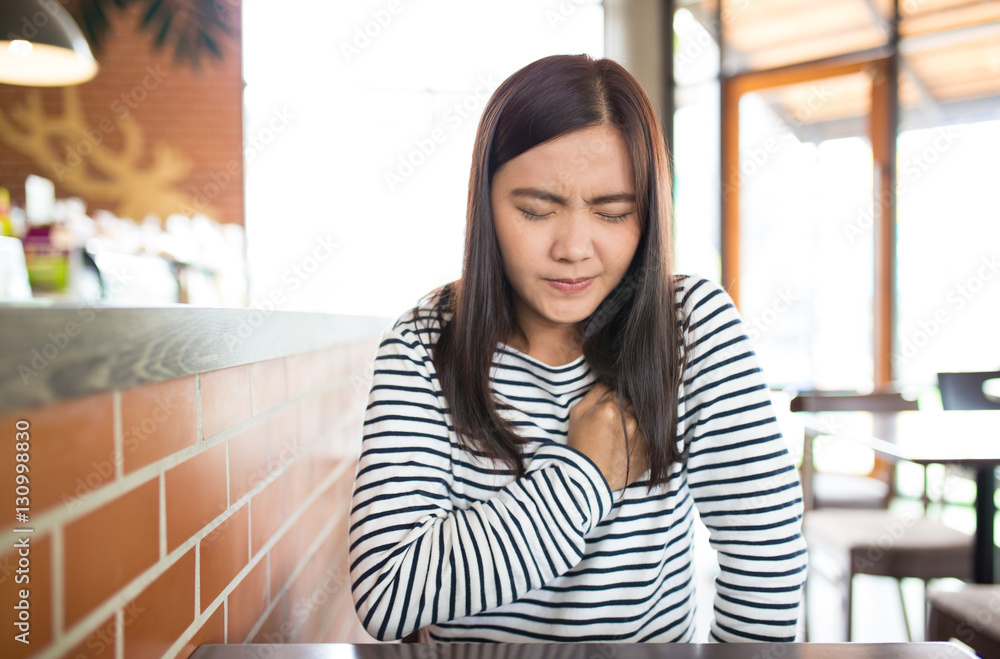Woman has chest pain in the cafe Woman has chest pain in the cafe