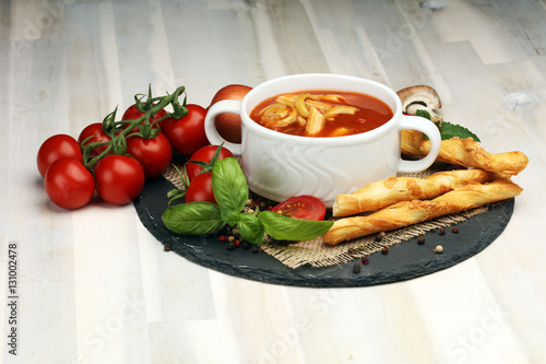 Tomato  red pepper soup  sauce with olive oil  rosemary and smoked paprika on a wooden background. 