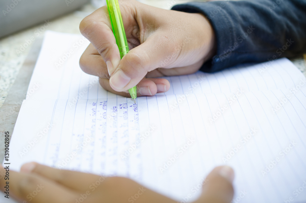 Child do his homework. Notebook for mathematic. Hand hold pen. B Child do his homework. Notebook for mathematic. Hand hold pen. B