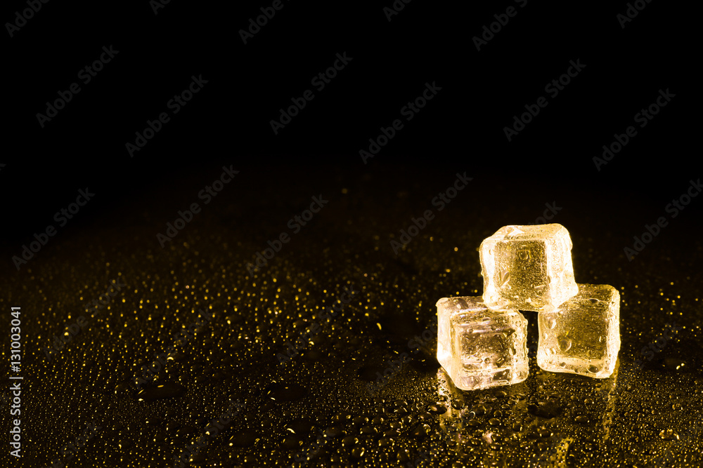Ice cubes in yellow light on black wet table. Ice cubes in yellow light on black wet table.