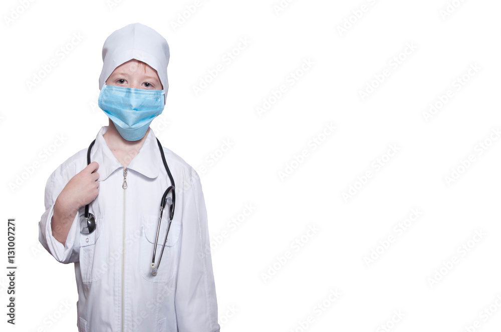 Child in a medical gown, cap, mask, stethoscope on a white backg Child in a medical gown, cap, mask, stethoscope on a white backg