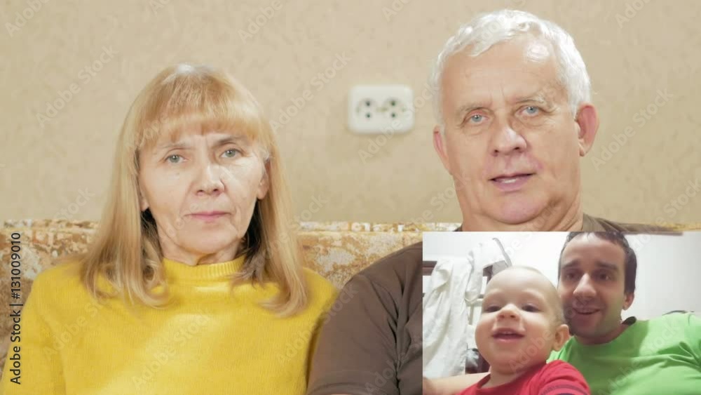 Senior couple communicates with the son and grandson on the internet. PIP: see the whole family on the screen. Dad and son hugging and kissing in the frame Senior couple communicates with the son and grandson on the internet. PIP: see the whole family on the screen. Dad and son hugging and kissing in the frame